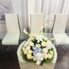 This centerpiece is an elegant, symmetrical floral arrangement featuring a refined palette