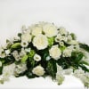 A classic white casket arrangement filled with roses, hydrangea, lisianthus, and stock
