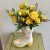 The cutest cowgirl boot, overflowing with bright and cheery yellow spray roses!