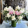 Lilies, White Rose, Eucalyptus, and more in cylinder glass vase.