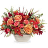 This autumn bouquet features light orange roses, miniature orange carnations, bronze cushion