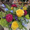 Ever changing mix of summer flowers enhanced with yellow roses and green