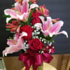 Beautiful one sided arrangement with roses, lilies and alstroemeria in a tall