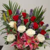 Red roses, white roses, stargazer lilys in a basket full of love.