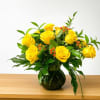 Dozen premium yellow roses arranged in a vase with greenery and accented