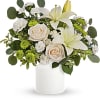 Roses, white lilies and carnations are accented with leaves of fragrant and