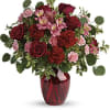 red roses and delicate pink alstroemeria are mixed with whimsical greens
