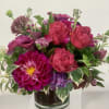 Moody, rich monochromatic arrangement of roses, calla lilies, lisianthus, hydrangea and dahlias
