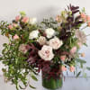 This beautiful tall arrangement features flowing fall foliage, dusty pink roses, ranunuclus