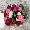 A charming seasonal arrangement presented in a keepsake teacup and saucer. Featuring