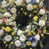 Roses, mini roses, lilies, and textured blooms arranged with greenery and delicate