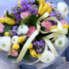 A cheerful and elegant mix of yellow tulips, soft pink carnations, fragrant