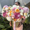 An opulent golden hatbox overflowing with a stunning medley of premium blooms