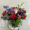 This flower arrangement is a beautiful blend of dark blue delphinium, hot