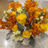 A bold and radiant arrangement of vibrant yellow roses, fiery orange orchids