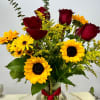 The red roses symbolize love and passion, while the bright yellow sunflowers