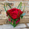 A tight arrangement of roses in a cube with a touch of