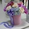 Roses orchids and more arranged in a beautiful lavender velvet hat box