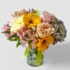 Roses orchids  and more arranged in a tall modern glass cylinder
