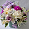 Lovely roses orchids and more arranged in a modern glass cube vase