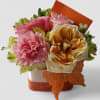 Roses and more arranged in a modern glass cube style vase wrapped