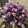 This shades of purple casket spray is a rich addition to any
