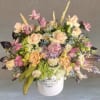 A dreamy mix of soft pink, lavender, peach, and green blooms, including