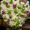 A full heart standing spray made with a collection of roses, calla