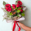 A dreamy arrangement of lush red roses, cheerful gerberas, and delicate berries