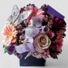 Roses orchids and more arranged in a black modern glass cube style
