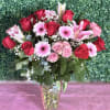 Red roses, lilies, baby&rsquo;s breath, spray roses, gerbera daisies, and eucalyptus arranged