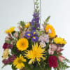 This lively basket arrangement is a burst of cheerful colors, featuring bright