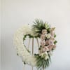 A heart wreath thoughtfully designed with fresh blooms to convey peace, love