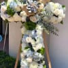 This cross-shaped arrangement offers a graceful symbol of faith and remembrance. Designed