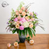 Elegant, tall floral arrangement in a glazed vase. 