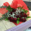 A dozen red roses wrapped with babies breath and green 