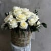 A timeless arrangement of velvety white roses, styled in a woven basket.