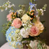 A beautiful blend of pastel blooms. Flowers include blue hydrangea, delphinium, light