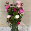 Peonies and green trick sweet William  arranged in a glass cylinder.