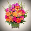 
Bursting with color and joy, this lively bouquet features bold orange roses