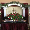 This striking funeral presentation features a trio of coordinated arrangements: a full