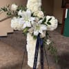 Graceful and timeless, this cross features a full bed of white blooms