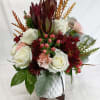 A rustic holiday celebration piece. White roses with Hypericum berries and Safari