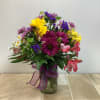 This floral arrangement, in a clear vase, is a vibrant and cheerful