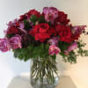 Nice arrangement with red roses and purple orquids nice arrange in a