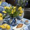 Tulips bloom gently from vintage-style pitcher, bringing a whisper of spring and