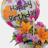 A cute small birthday basket mixed with bright in season blooms carnations