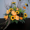 Bold bright sunflowers, roses and marigolds nestled in a cascade of birch