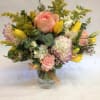 Stock, tulips, roses,spray roses, solidago and seasonal filler create a soft and
