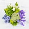 This arrangement includes green dianthus, blue iris, white tulips, hyacinths, and other